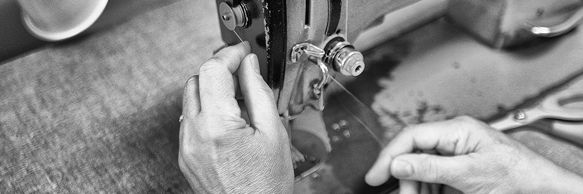 A San Bushman sits on a 4x4 seat overlooking the plains and another truck