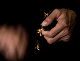 Bright orange sparks shoot out from a flint and steel striker.